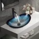 Ovalni namizni umivalnik z elegantnim dizajnom in visokokakovostnim steklom. Primeren za vgradnjo na vse ravne površine. Z veliko konstrukcijo za preliv, vključno s pipami za hladno in toplo vodo ter 